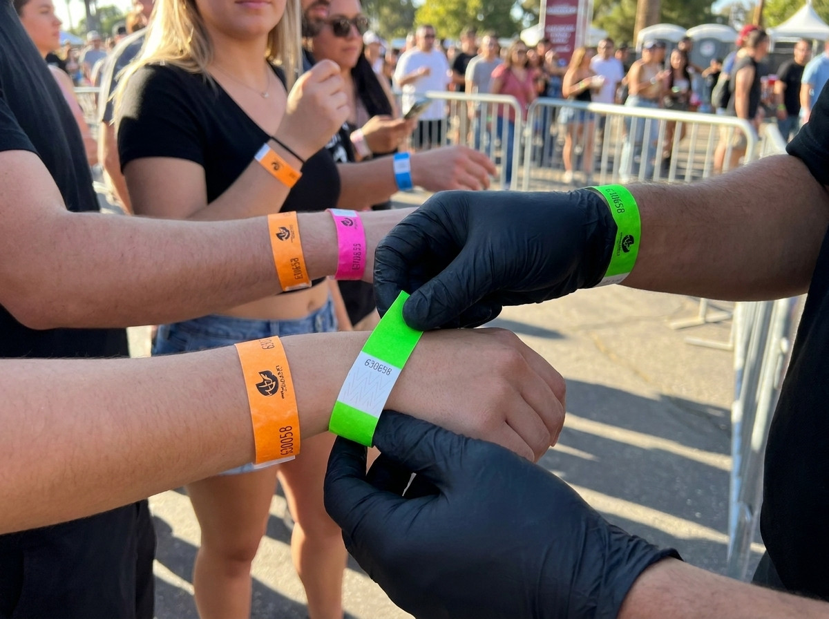 Agente de seguridad comprobando pulseras de colores en el punto de acceso