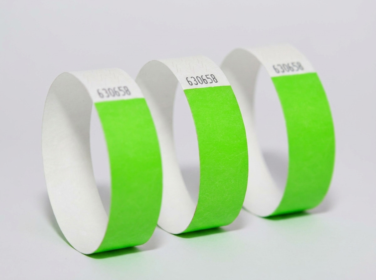 Comparativa lado a lado de una pulsera Tyvek de colores y una pulsera identificativa blanco elegante sobre un fondo de madera clara