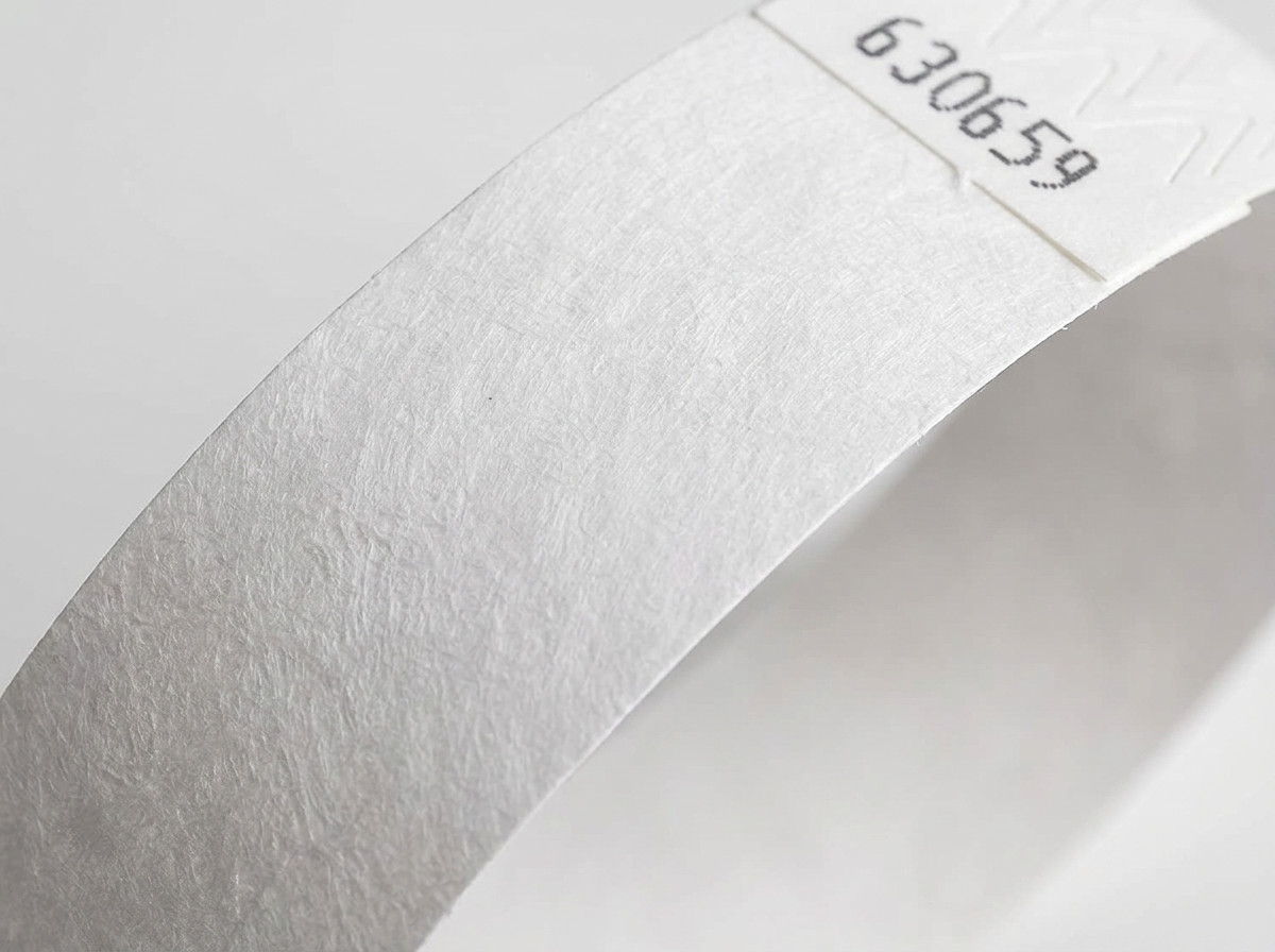 Primer plano de la superficie no tejida de una pulsera Tyvek blanca, mostrando la textura característica del polietileno de alta densidad